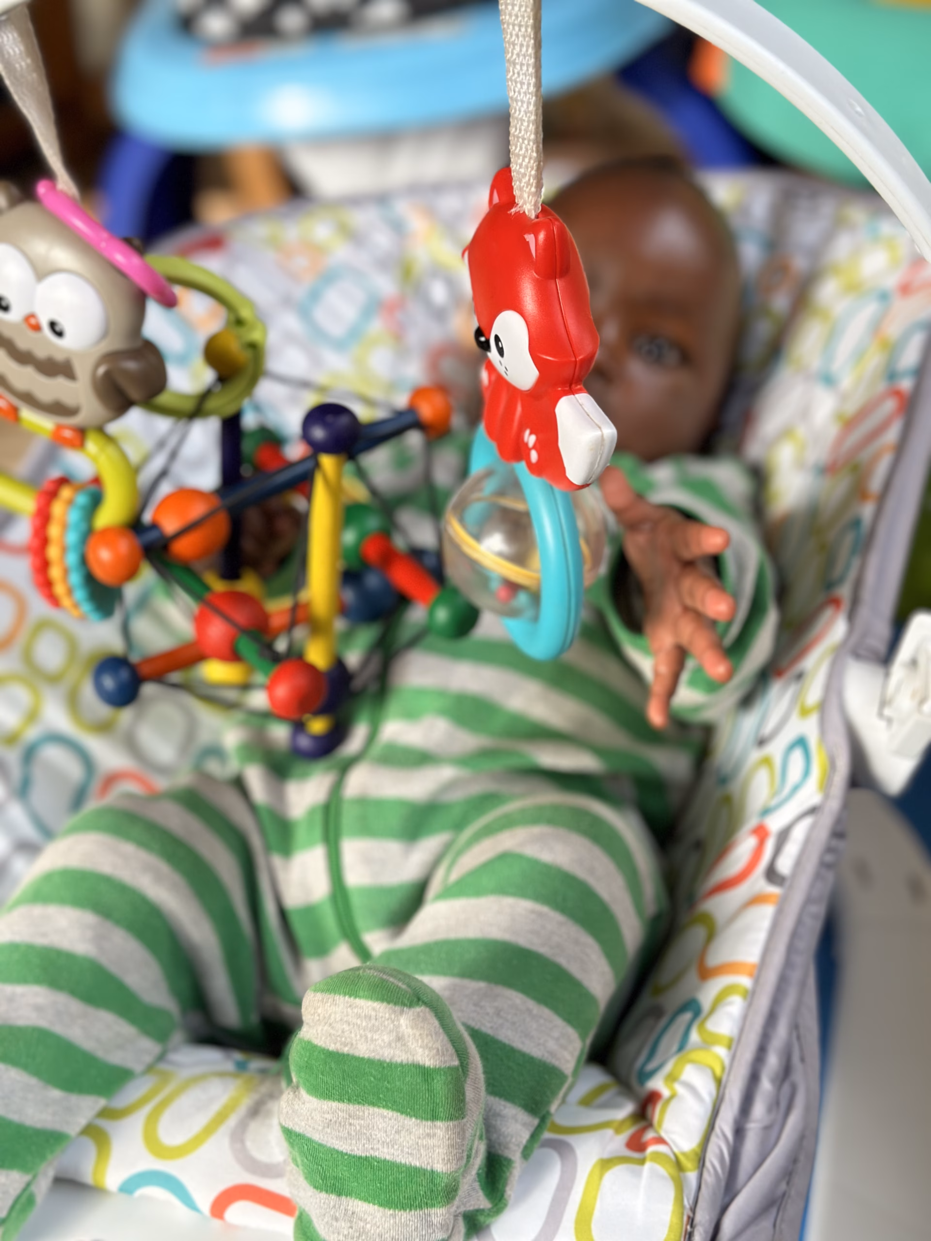 A baby reaching for a toy at His Cherished Ones