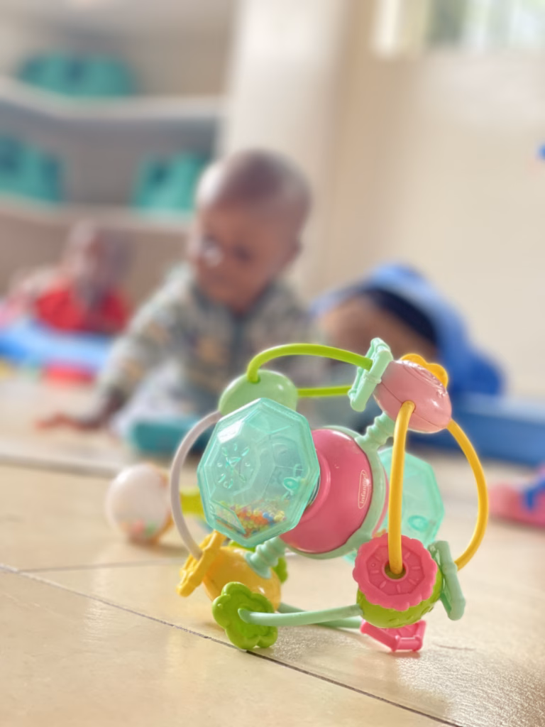 Babies playing with colorful toys at His Cherished Ones