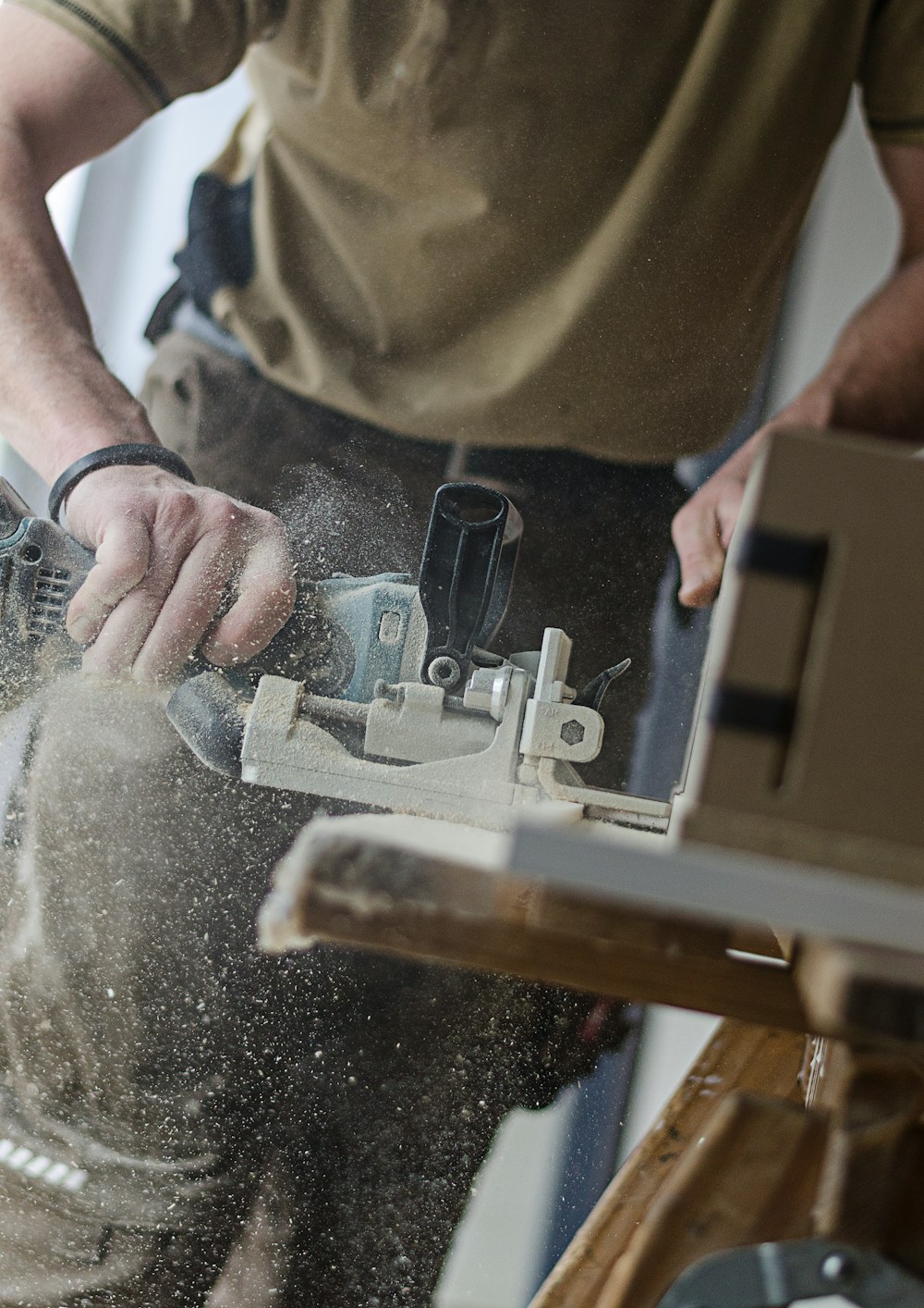 Hands using a biscuit joiner on a timber board